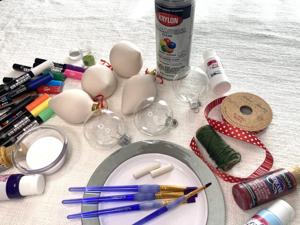 Supplies needed for hand painted ornaments include paintbrushes, paints, ribbons, and ornaments