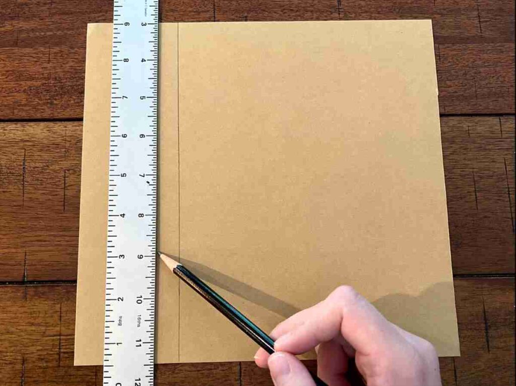 Using and ruler and pencil to measure on a piece of scrapbook paper