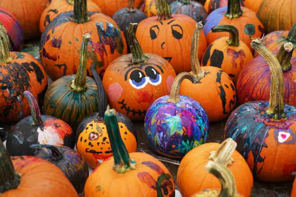 A bunch of pumpkins with painted faces