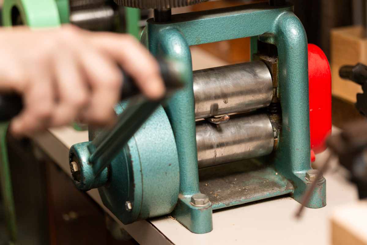 Jeweler using a jewelry roller mill to stretch a piece of wire