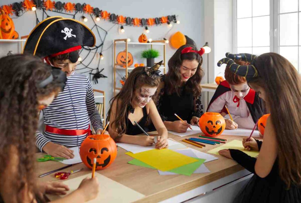 A group of older kids in Halloween costumes making decorations