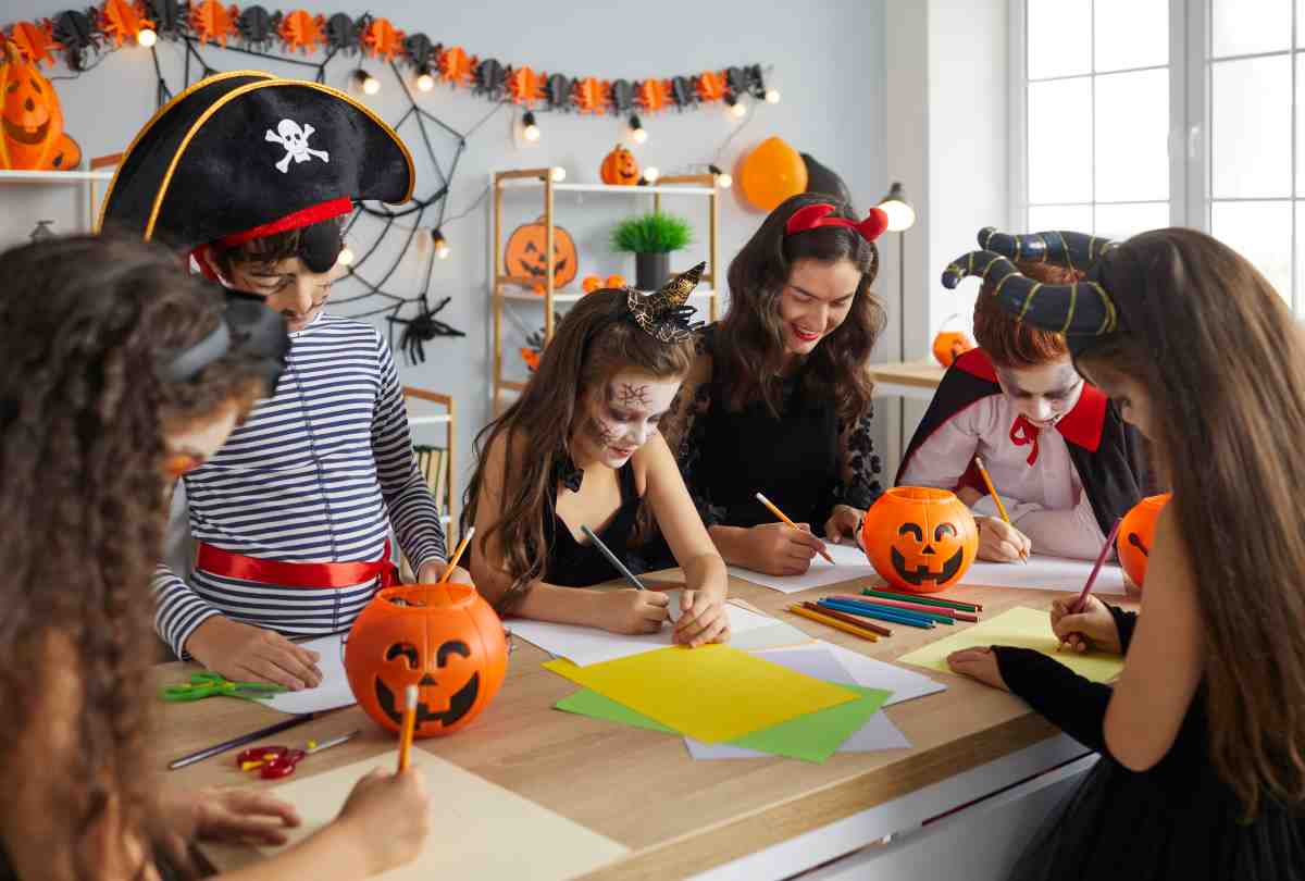 A group of older kids in Halloween costumes making decorations