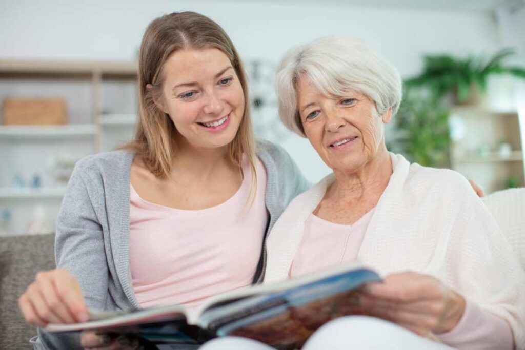two women looking at a completed scrapbook