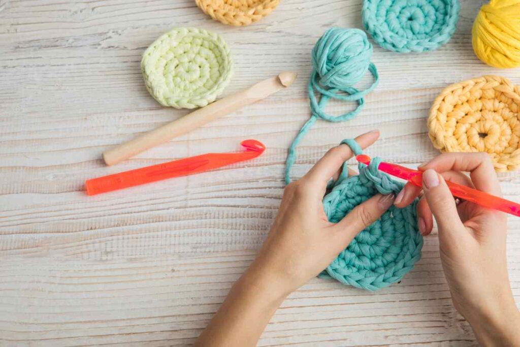 Woman crocheting teal and yellow circles