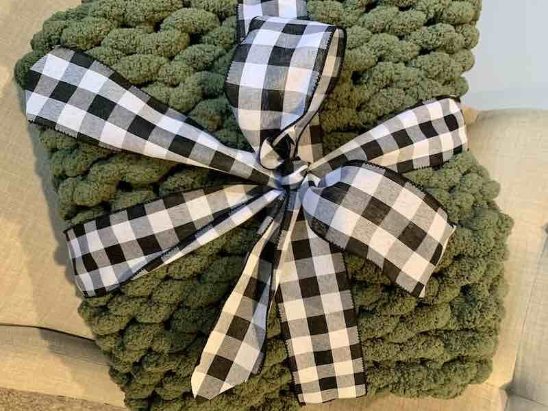 Finished Chunky Knit Blanket with a bow wrapped around it. 